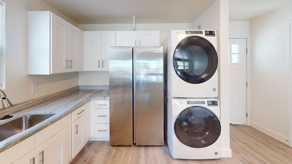 A modern kitchen with a stainless steel refrigerator and a white dishwasher.